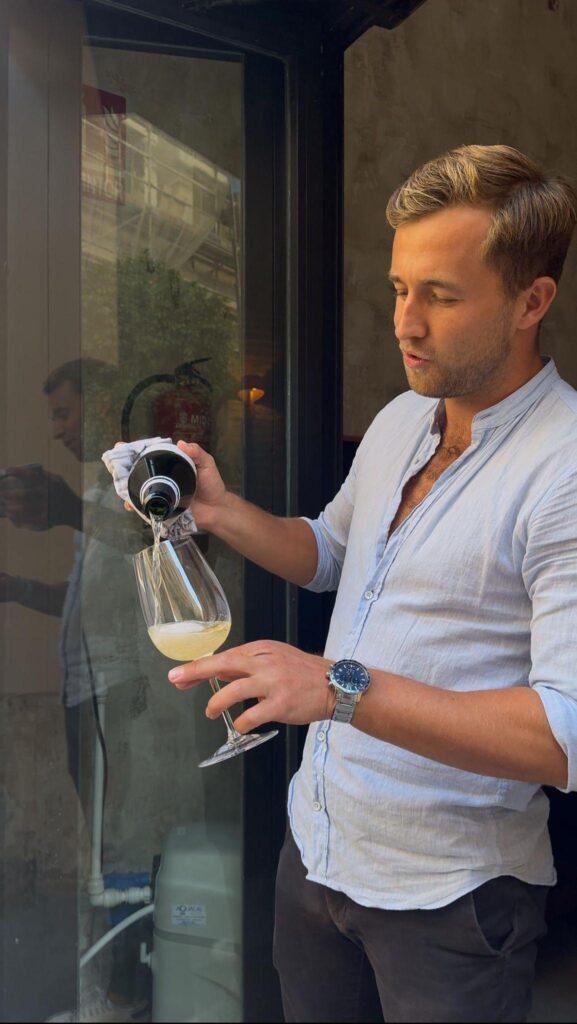 Sommelier Tristan is pouring a glass of cava during one of the wine tastings in Valencia