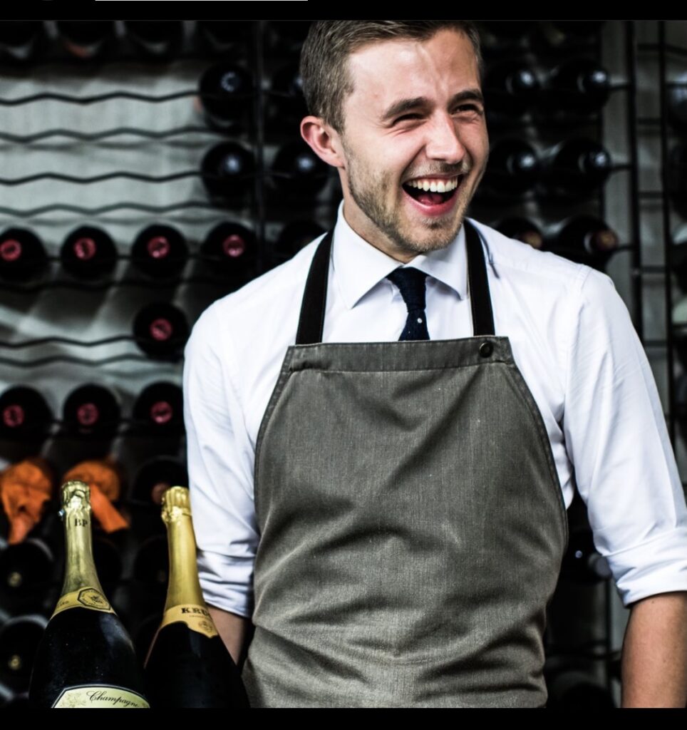 Sommelier Tristan die wijn laat zien bij een wijnproeverij.